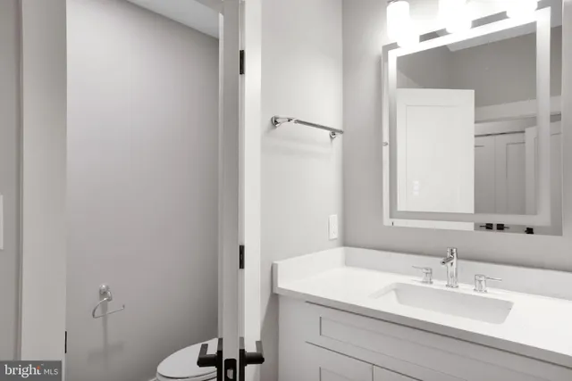 a bathroom with a sink vanity mirror and toilet