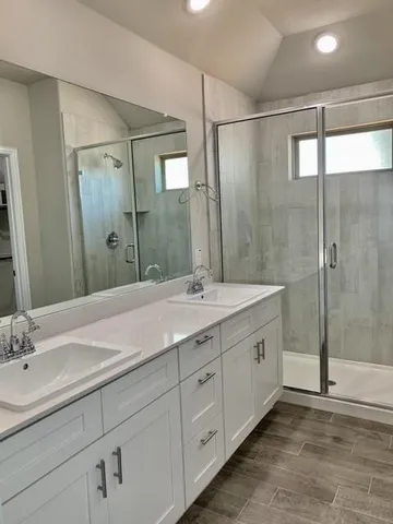 an empty room with wooden floor chandelier fan and windows