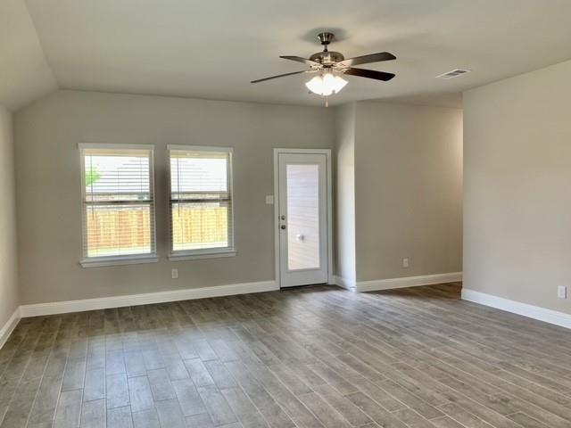 4404 Thalia Way Forney, TX 75126 - Photo 17 of 20 an empty room with wooden floor chandelier fan and windows