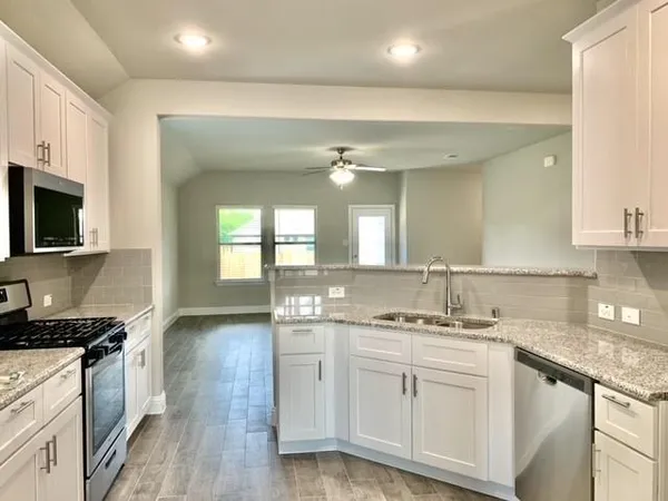 a kitchen with a sink stove and cabinets