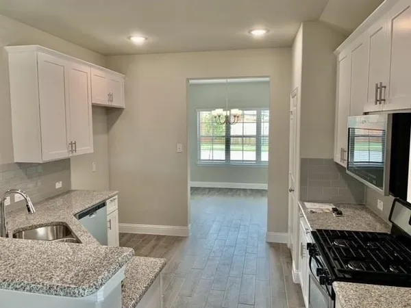 a kitchen with granite countertop a stove and a sink