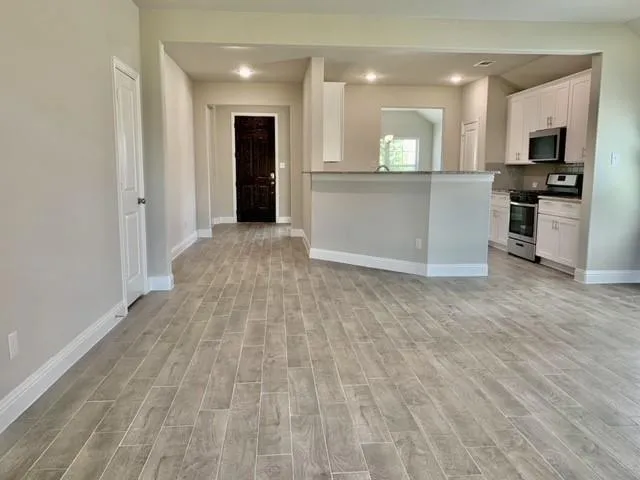 a view of a kitchen with wooden floor and a sink