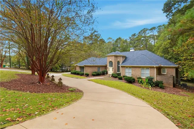 a view of a house with a yard and large tree
