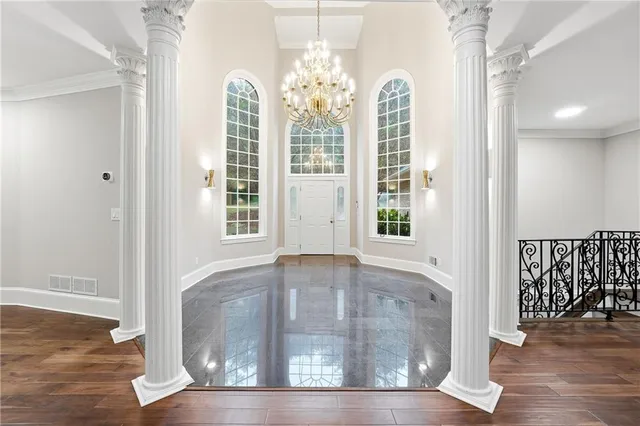 a view of a hallway with windows and chandelier