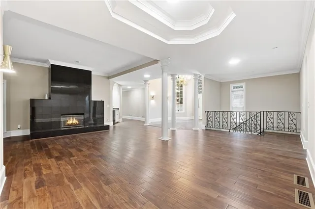 a view of a livingroom with wooden floor and a fireplace