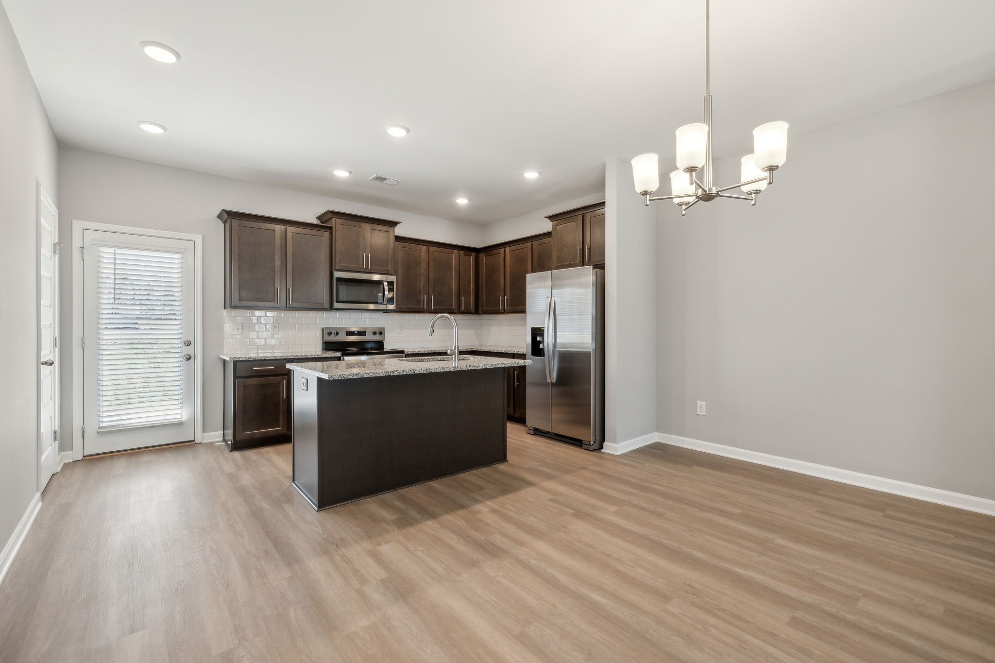 Undisclosed Address Lebanon, TN 37087 - Photo 9 of 13 a kitchen with stainless steel appliances granite countertop a refrigerator a sink dishwasher a stove and a dining table with wooden floor