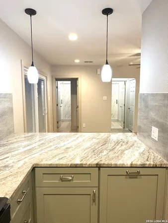 a bathroom with a granite countertop sink and a chandelier