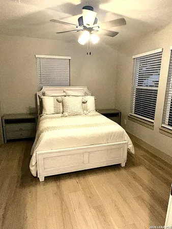 a large white bed sitting in a bedroom next to a window