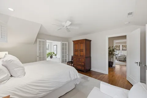 a bedroom with a large bed and wooden floor