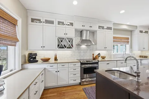 a kitchen with granite countertop a sink stove and cabinets