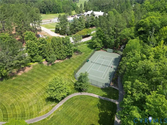 an aerial view of residential houses with outdoor space and trees