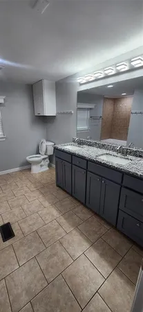 a kitchen with granite countertop a sink a stove and cabinets