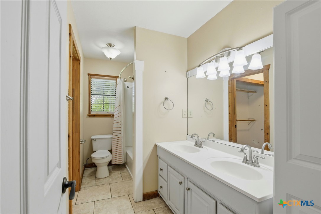 903 Summit Street Round Rock, TX 78664 - Photo 15 of 38 Primary full bath area with double vanity, and tub/shower combination. Neutral and natural lighting.