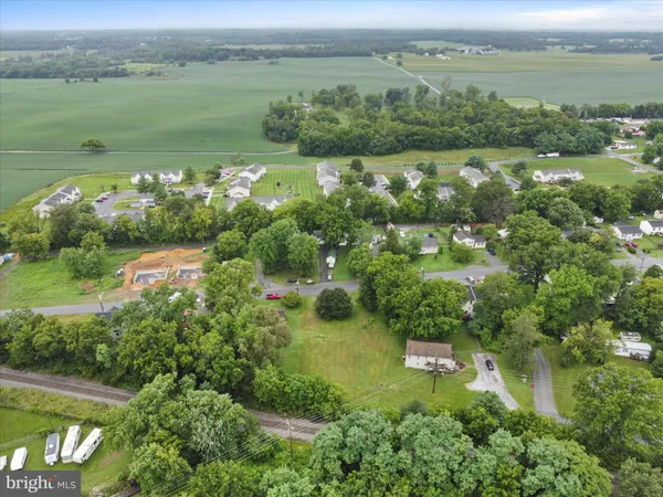 an aerial view of green landscape with trees houses and lake view
