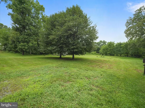 a view of a green field with wooden fence