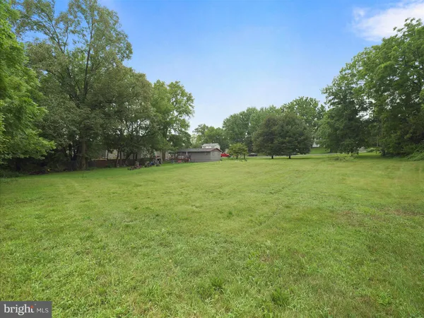 a view of a field of grass and trees