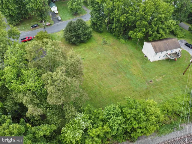 an aerial view of residential house with outdoor space and trees all around