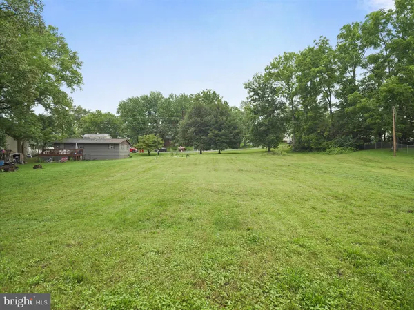 a view of a green field with trees in the background