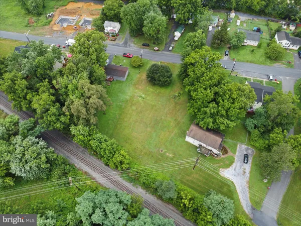 an aerial view of residential house with outdoor space and trees all around