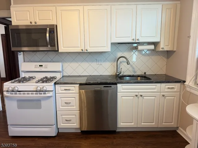a kitchen with stainless steel appliances granite countertop a stove and a microwave