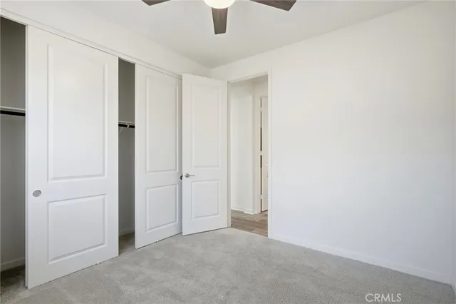 an empty room with chandelier fan