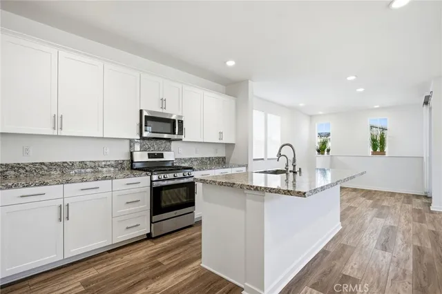 a kitchen with white cabinets and stainless steel appliances