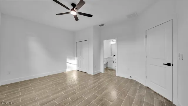 a view of an empty room and window a ceiling fan