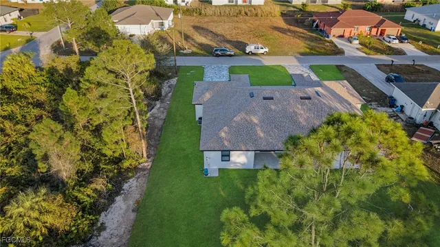 an aerial view of residential house with outdoor space and trees all around