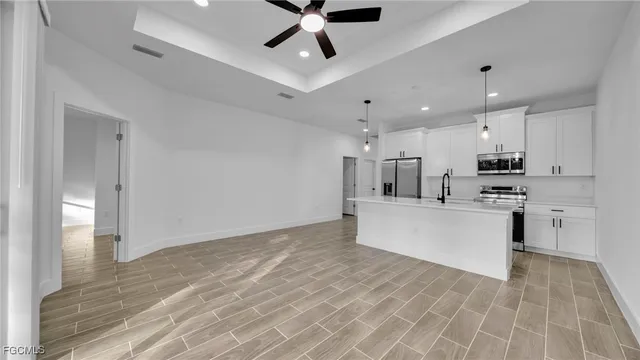 a view of kitchen with stainless steel appliances refrigerator stove microwave and cabinets