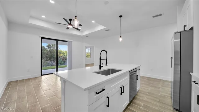 a kitchen with stainless steel appliances granite countertop a sink and refrigerator