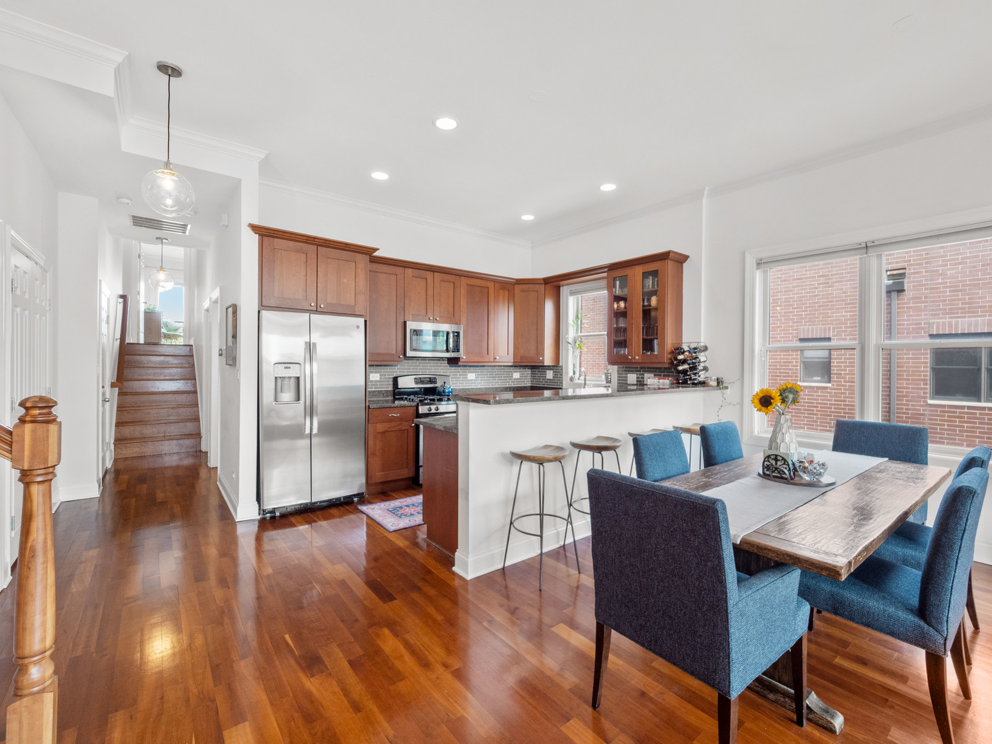 2940 North Sheffield Avenue, Unit 4N Chicago, IL 60657 - Photo 10 of 32 a open kitchen with stainless steel appliances granite countertop a refrigerator a stove a sink a dining table and chairs with wooden floor