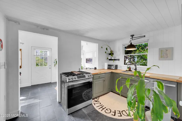 a kitchen with stainless steel appliances granite countertop a stove a sink and a refrigerator