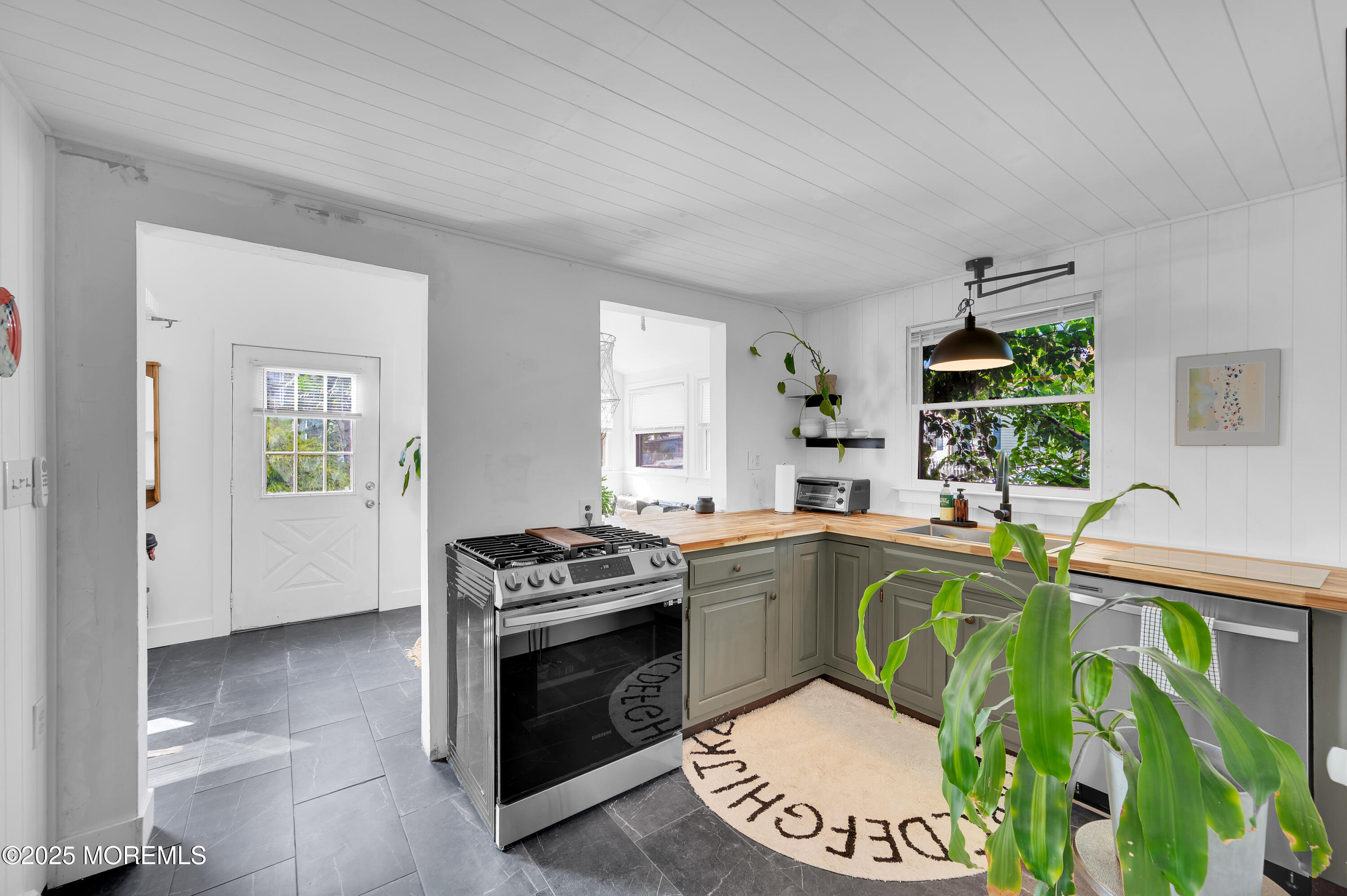 a kitchen with stainless steel appliances granite countertop a stove a sink and a refrigerator