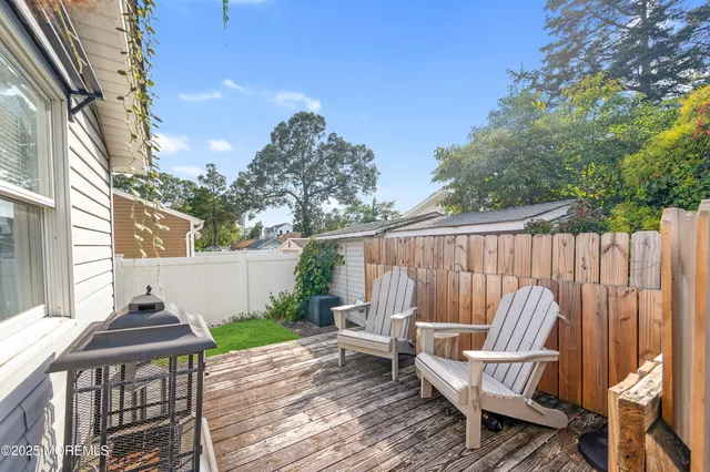 a view of a chair and table in backyard of the house