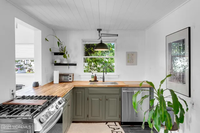 a kitchen with kitchen island granite countertop a sink stainless steel appliances and cabinets
