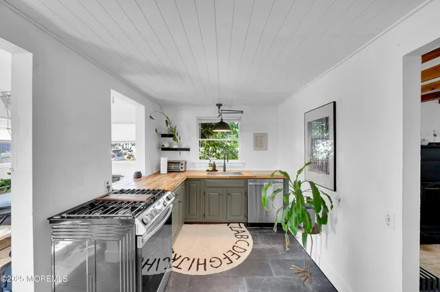 a kitchen with a stove a sink and a window