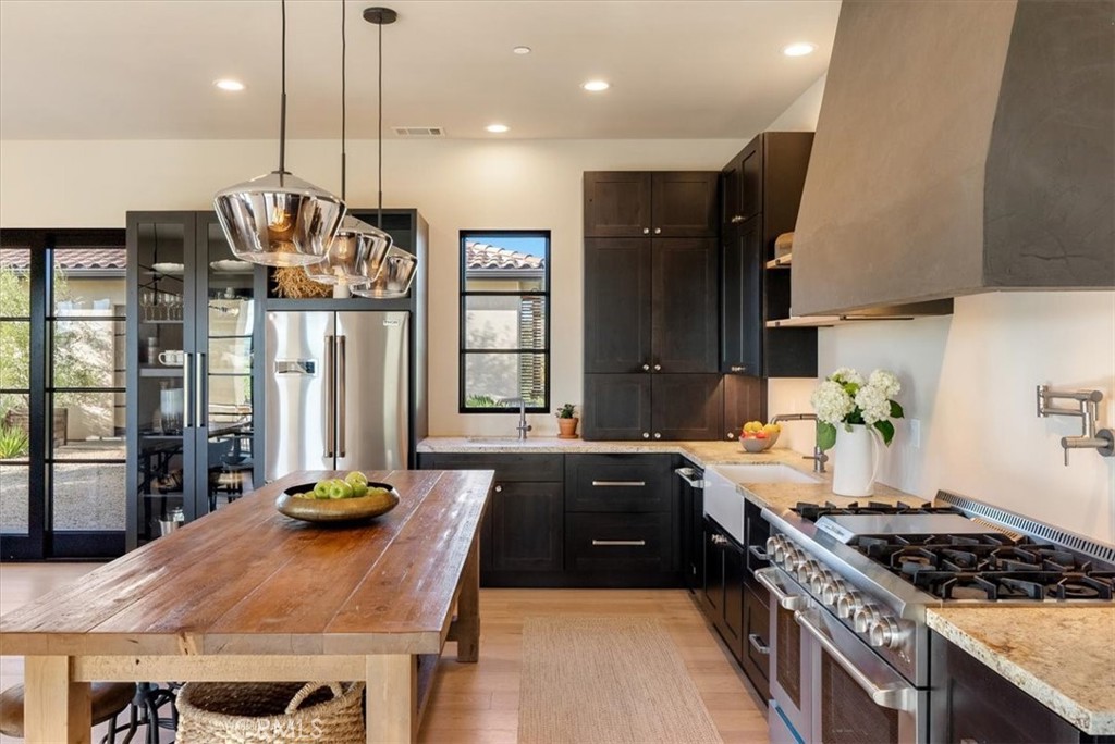 3940 Gruenhagen Flat Road Paso Robles, CA 93446 - Photo 15 of 63 a kitchen with stainless steel appliances granite countertop a stove a refrigerator a sink a dining table and chairs with wooden floor