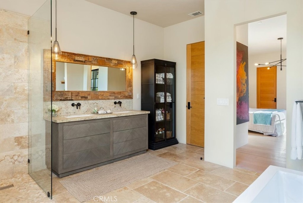 3940 Gruenhagen Flat Road Paso Robles, CA 93446 - Photo 23 of 63 a bathroom with a double vanity sink a mirror and a bathtub