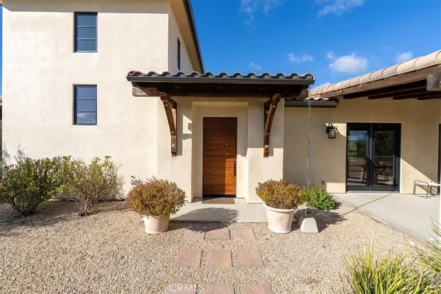 a living room with furniture kitchen view and large windows