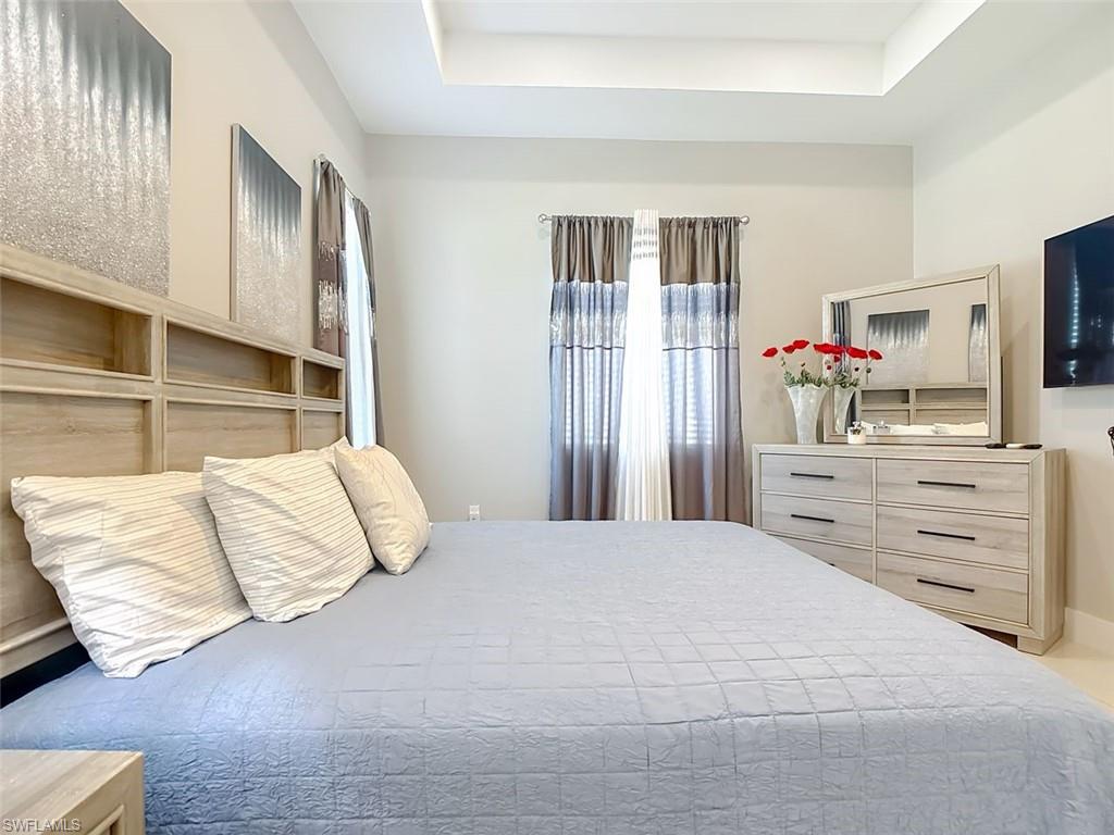 1806 41st Street Southwest Naples, FL 34116 - Photo 16 of 27 a bedroom with a bed and wooden floor