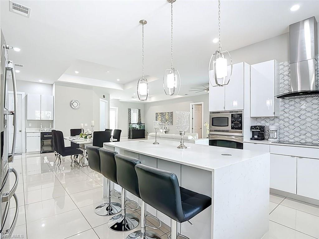 1806 41st Street Southwest Naples, FL 34116 - Photo 18 of 27 a large kitchen with a table and chairs