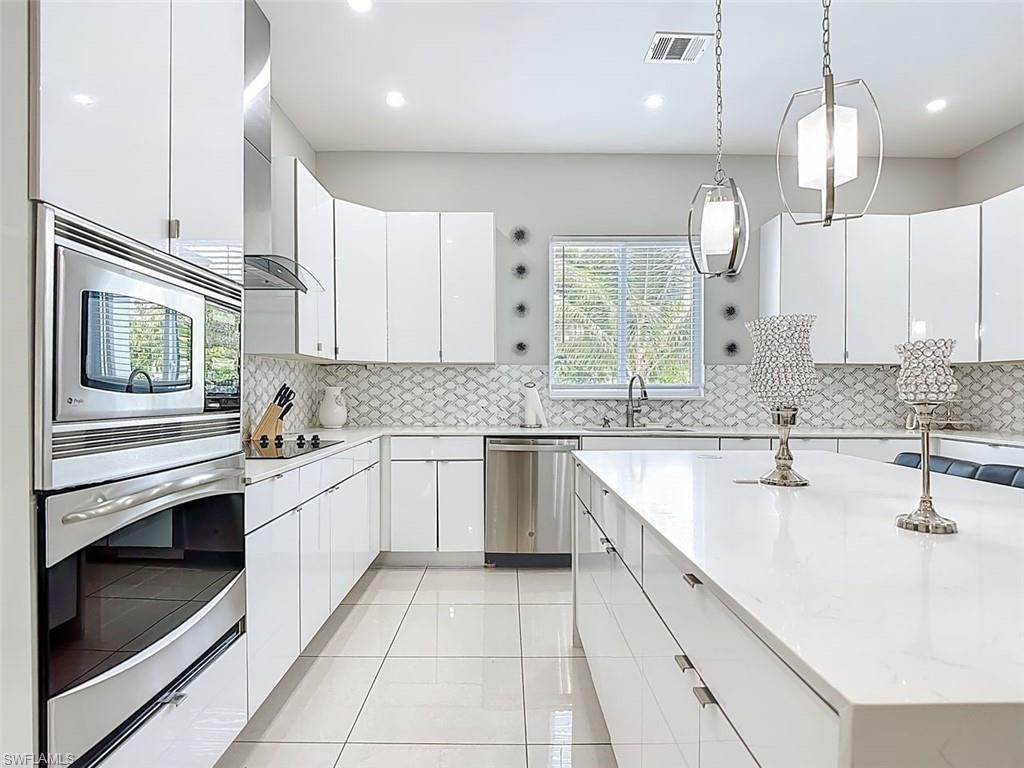 1806 41st Street Southwest Naples, FL 34116 - Photo 22 of 27 a kitchen with a sink stainless steel appliances and cabinets
