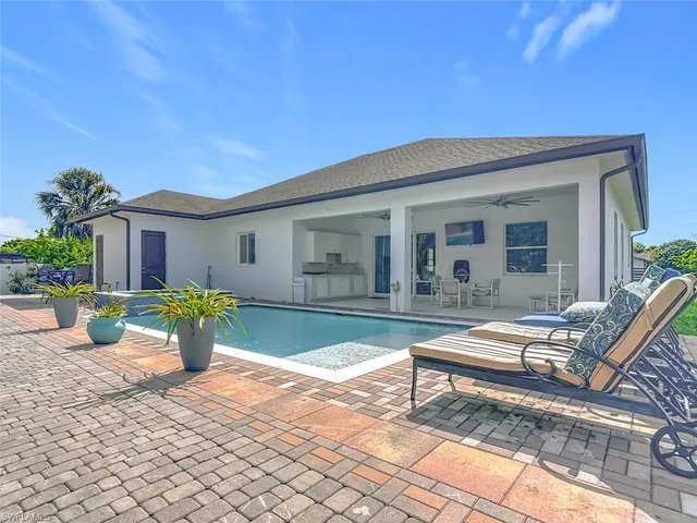 a view of a house with backyard and sitting area