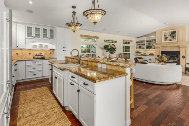 a very nice looking kitchen with granite countertop a stove oven and a sink