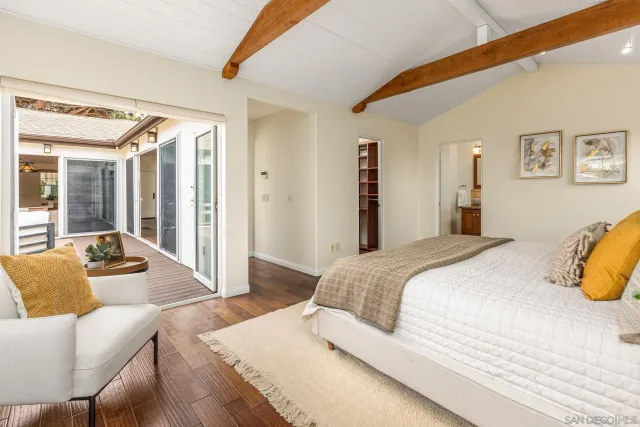 a bedroom with a bed couch and a large window