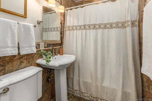 a bathroom with a sink a mirror and a shower curtain
