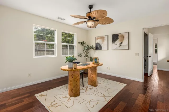 a dining room with wooden floor a chandelier a wooden table and chairs