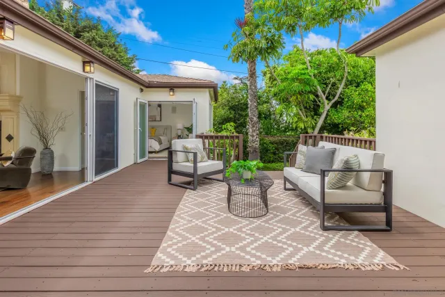 a living room with patio furniture and garden