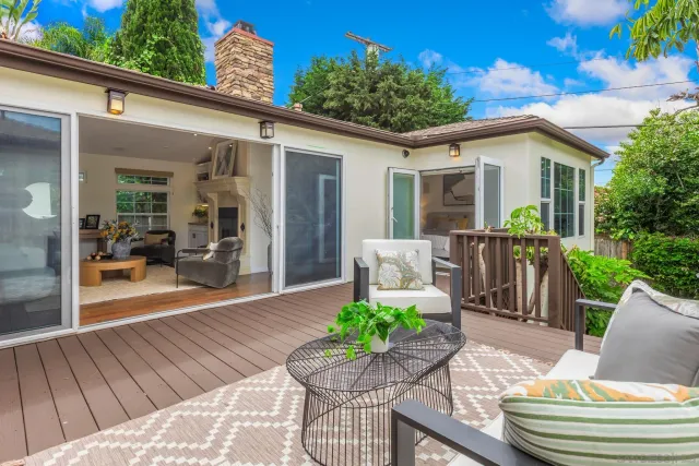 a view of a patio with couches table and chairs and potted plants