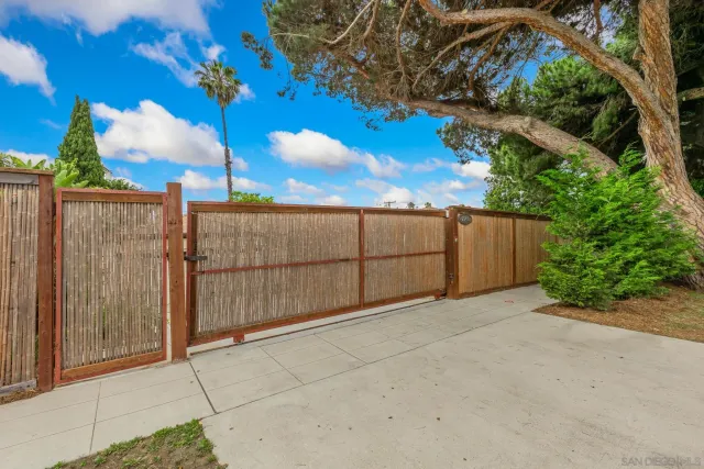 a view of backyard with potted plants and wooden fence